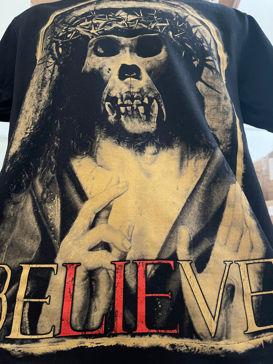 angle view of believe monkey skull shirt with red LIE letters