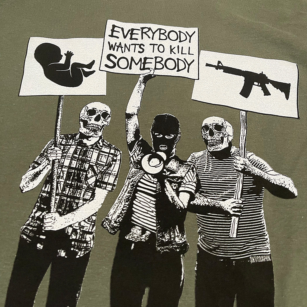 protesters with picket signs and skulls on green shirt