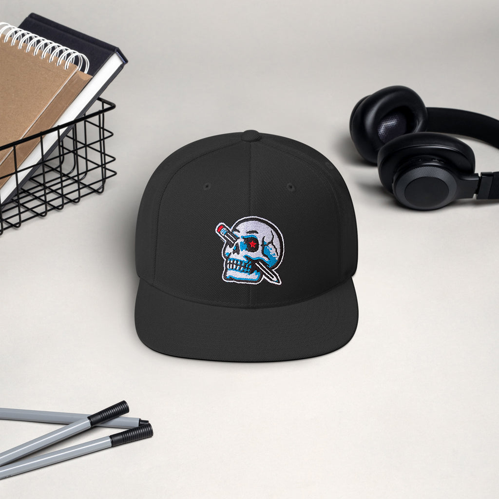 pencil skull hat with various items in background, headphones, notebooks, pens