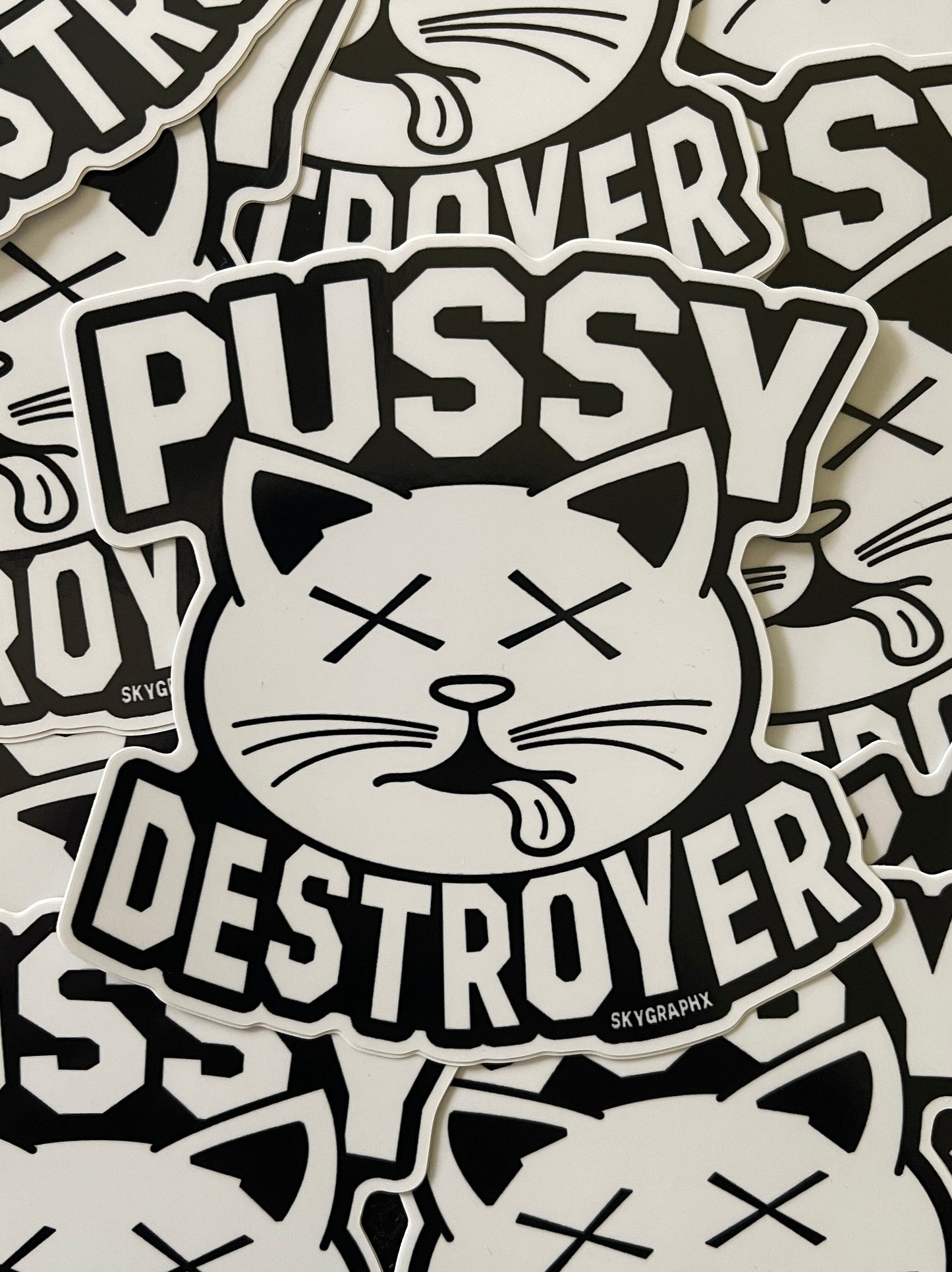 Sticker design with cat face and text 'PUSSY DESTROYER' on a patterned background