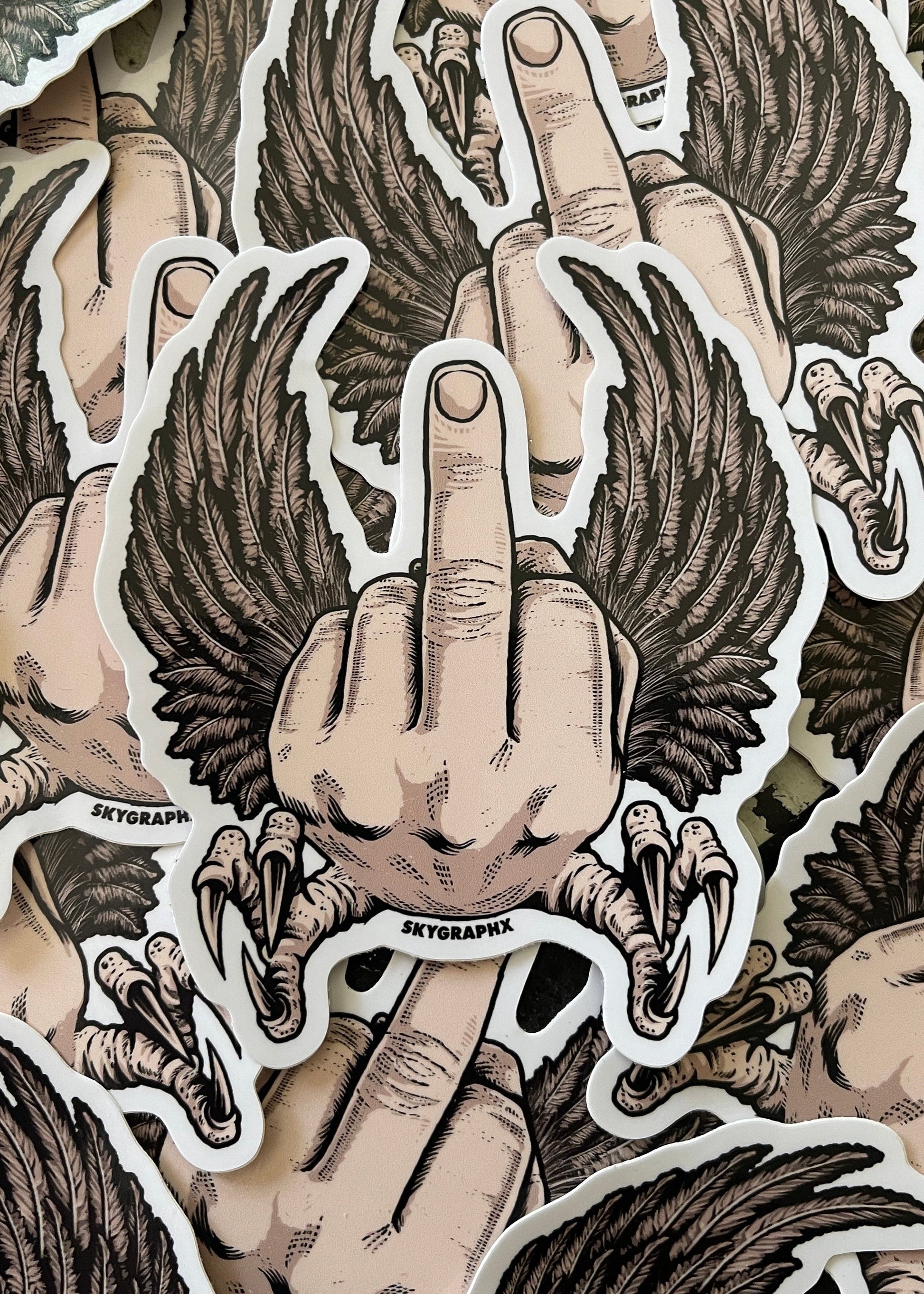 Sticker design of a hand with wings giving the middle finger, featuring the brand 'Skygraphx'.